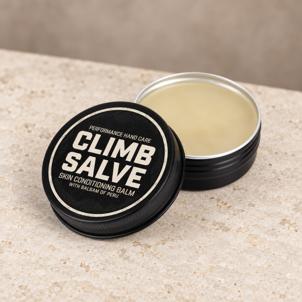 Open Climb Salve balm with black lid on a stone surface