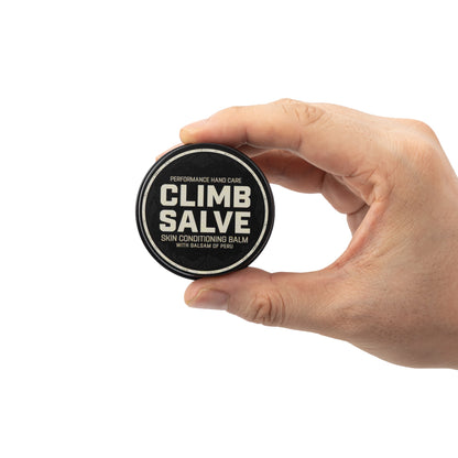 Climb Salve tin held in a hand to show its size