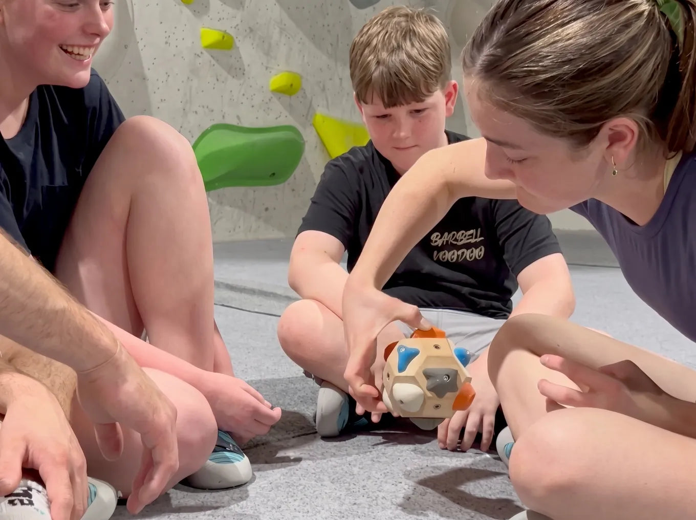 Kids sitting on the floor at a climbing gym, playing with the Boulder Block