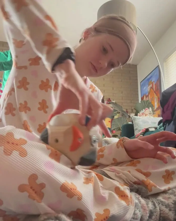 A teenage girl in pyjamas on the living-room floor, working a route on the Boulder Block